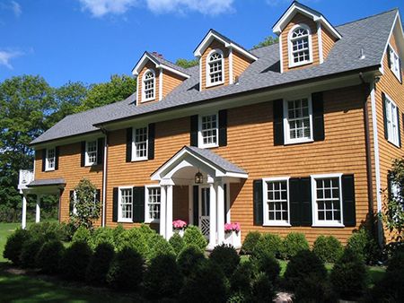 estate home with cedar shingles and black shutters